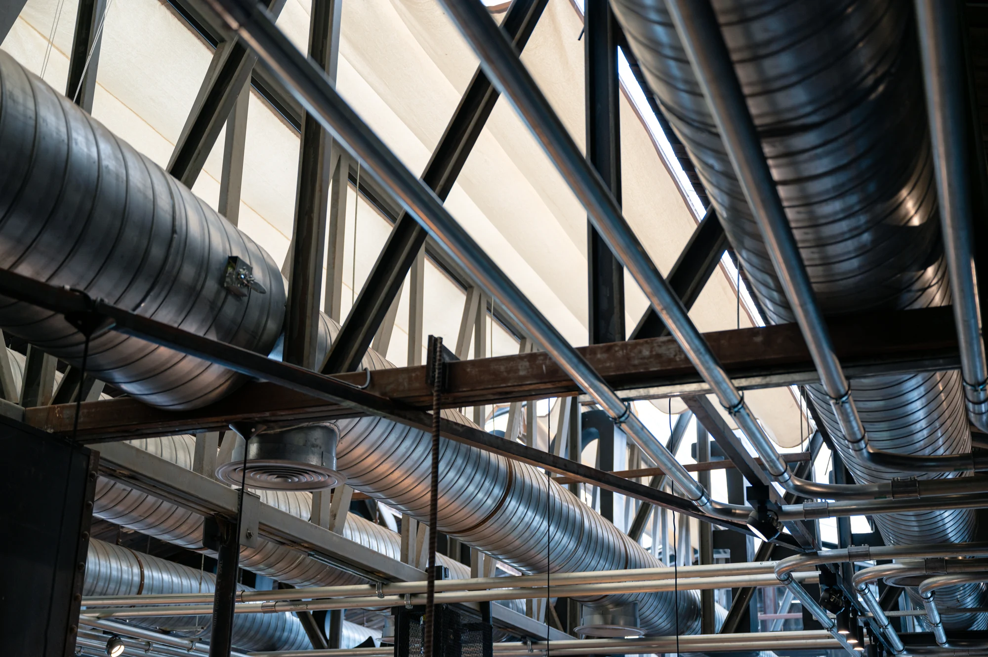Ventilationskanaler och stålkonstruktion i en industribyggnad Ventilationskanaler och stålkonstruktion i en industribyggnad