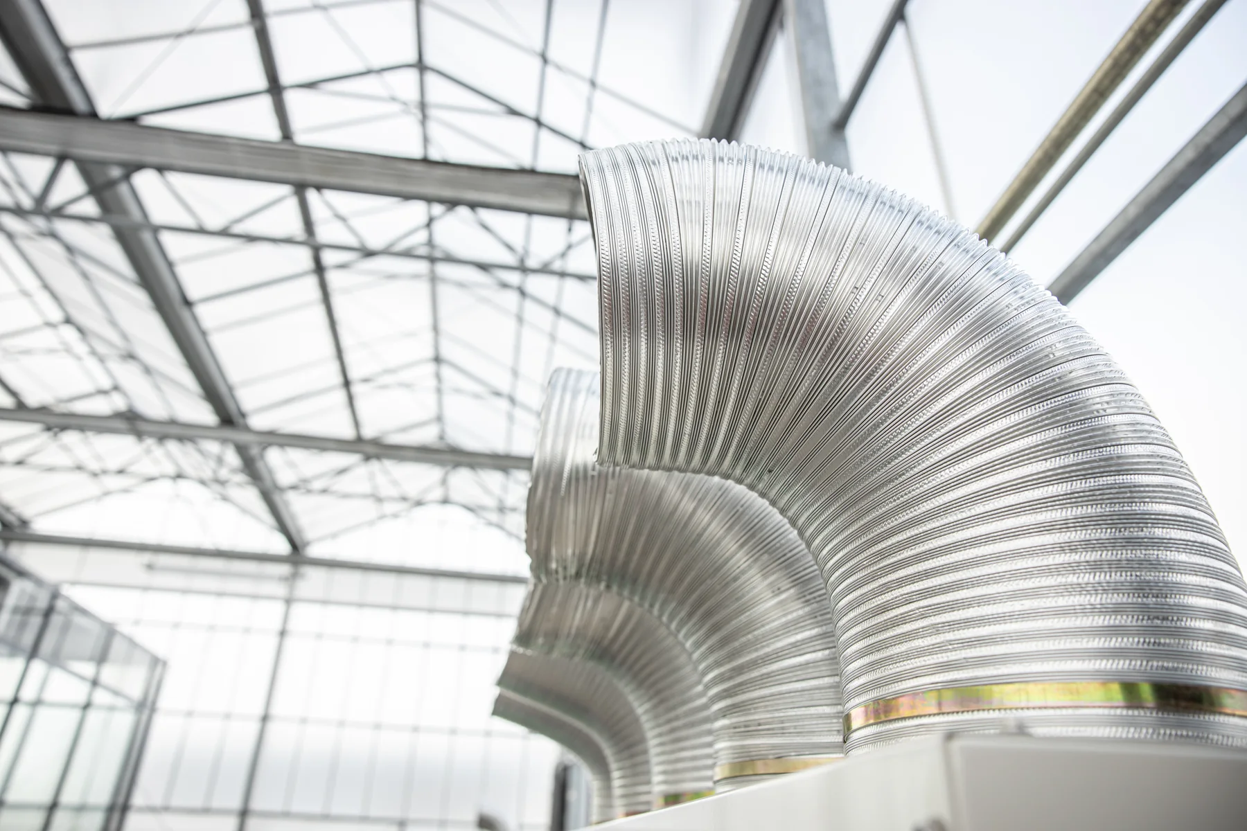 Böjda ventilationskanaler i aluminium under ett glastak